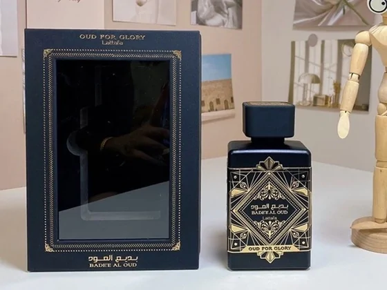 Frasco de perfume oscuro junto a su caja